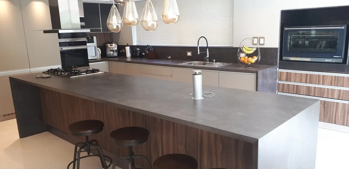 Cocina de proyecto con isla de piedra, fabricada y colocada por Marmolería Gaona