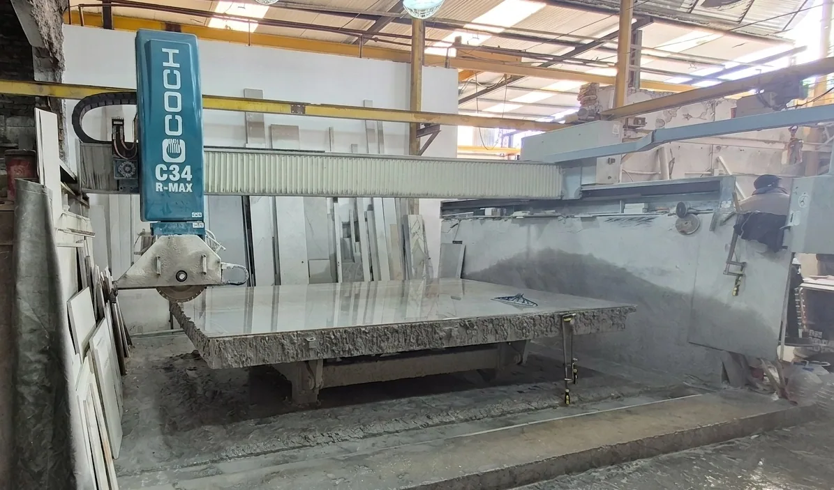 Máquina de corte trabajando una placa de piedra en el taller de Marmolería Gaona, en Villa Sarmiento