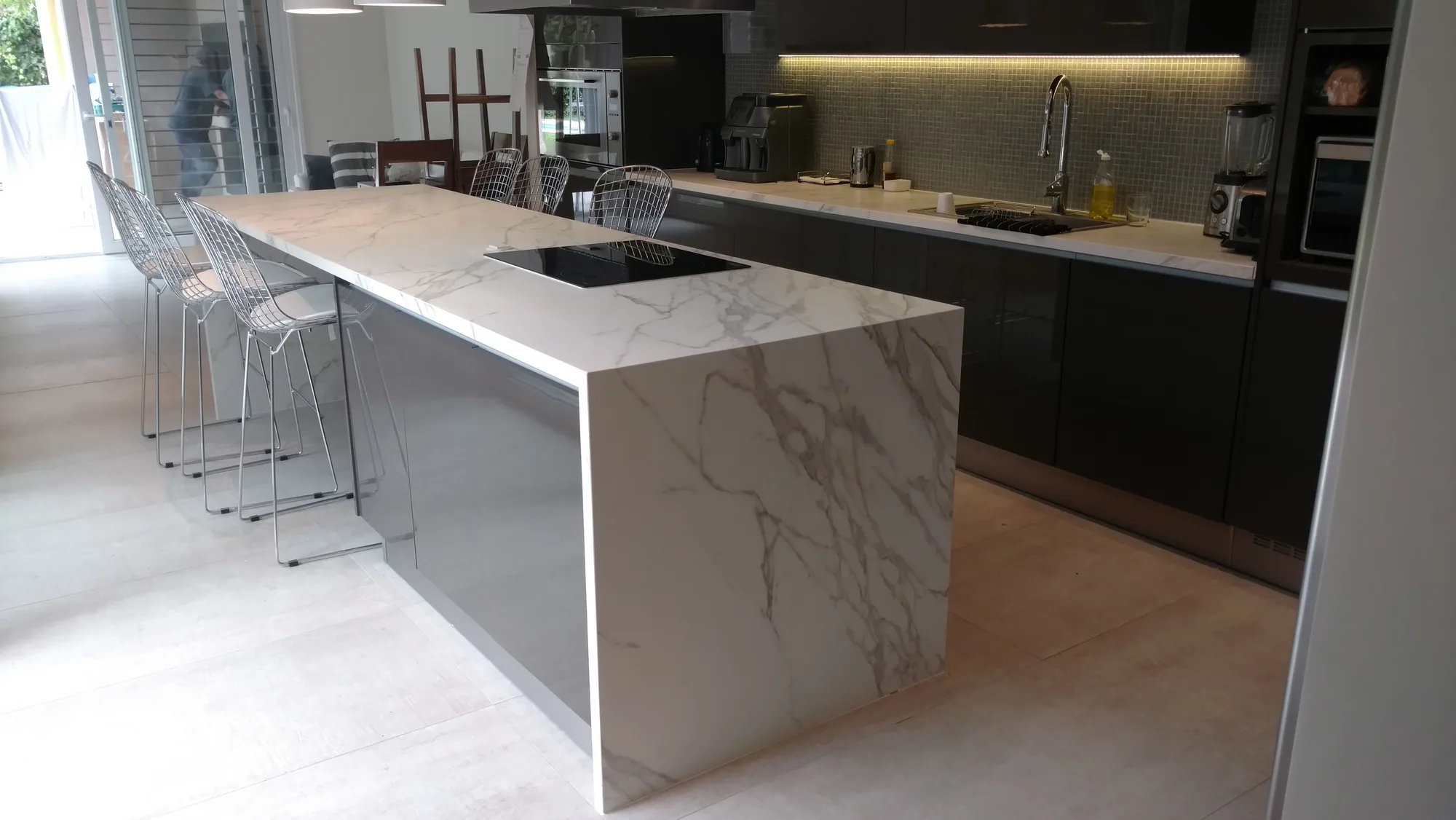 Isla de cocina con mesada y frente de piedra de veta blanca, fabricada y colocada por Marmolería Gaona